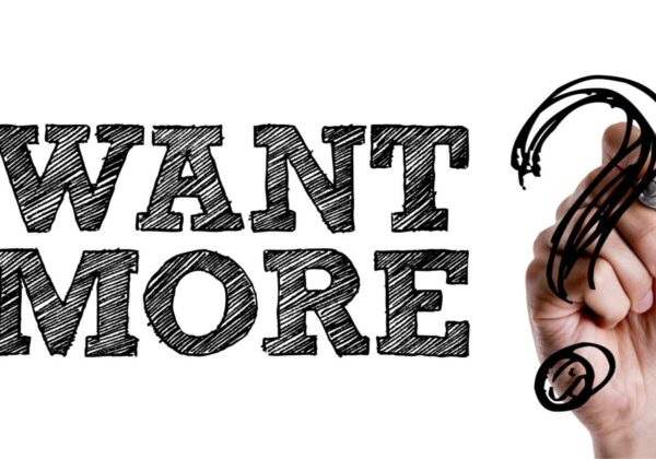 Writing of the two words want more, with a hand writing a question mark.