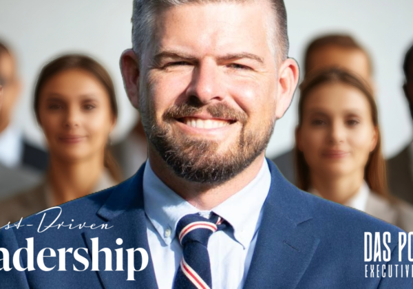 Sascha Schneider of Das Potenzial stands amidst a group of people collaborating, with the words 'Trust-Driven Leadership' overlaid on the image. This image relates to an article about how trust-driven leadership fosters strong teams and effective communication